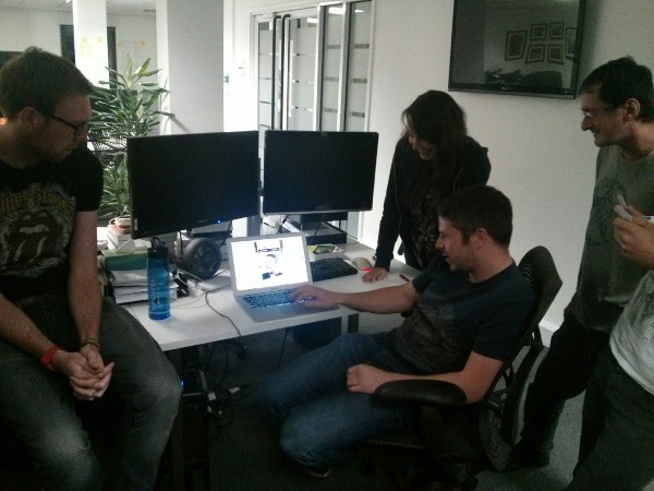 A group of people gathered around a laptop